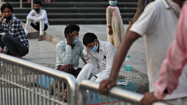 Relatives of admitted patients wearing face masks as a precaution against coronavirus talk outside a hospital in New Delhi earlier this month.