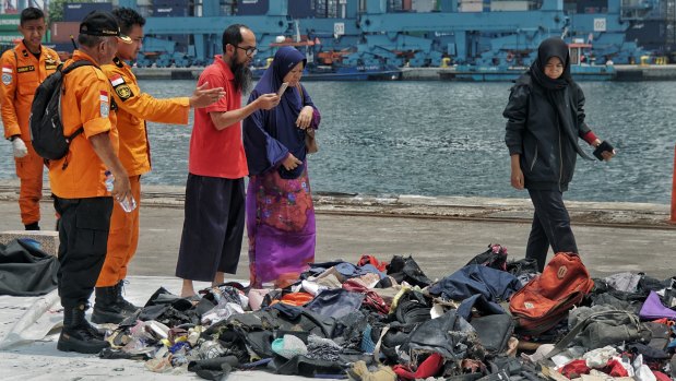 Families scan the debris and personal belongings believed to be from the crashed jet.