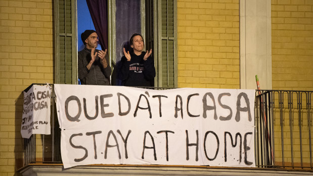 People applaud from a balcony during a flash mob called through social media and messaging platforms, aimed to thank workers in the fight against coronavirus in Barcelona, Spain. 