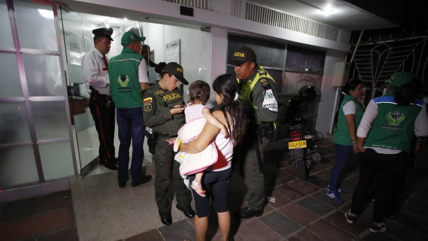 Police attend to 17-year-old Venezuelan Eliusmar Guerrero and her 18-month-ols daughter at a child welfare office where she can get food and a temporary place to sleep in Cucuta, Colombia. 