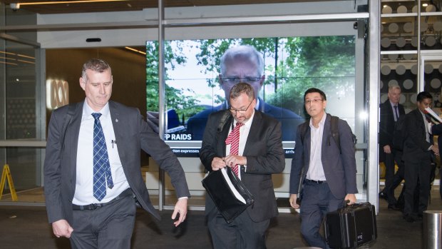 AFP officers leave the ABC Sydney building on Wednesday evening.