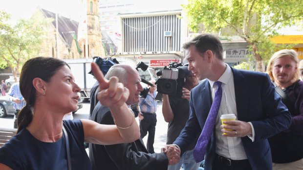 Liberal candidate for Reid Fiona Martin (left) on a street walk in Burwood with John Howard, who is interrupted by Labor candidate Sam Crosby.