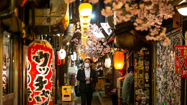 A man walks through the Shinjuku area of Tokyo as COVID cases surge in Japan. 
