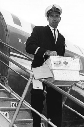 First batch ... Mr Noel Murphy from TAA hurries the blood package down the steps of an airliner.