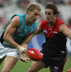 Travis Johnstone chases Port’s Kane Cornes.