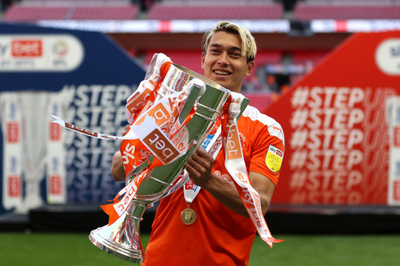 Dougall holds up the trophy after Blackpool’s promotion.