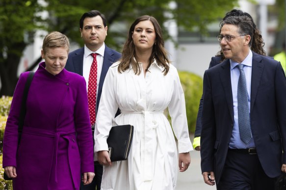 Brittany Higgins (centre) arrives at the ACT Supreme Court in Canberra on Friday, flanked by her legal team and support worker.