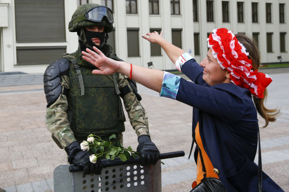 A woman runs to embrace a soldier guarding a Belarusian government building in Minsk.