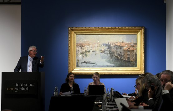 Auctioneer Roger McIlroy with Arthur Streeton’s painting The Grand Canal, 1908, auctioned at Deutscher and Hackett in Melbourne.  