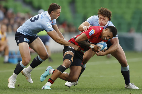 Harry Wilson of the Waratahs tackles Chay Fihaki of the Crusaders