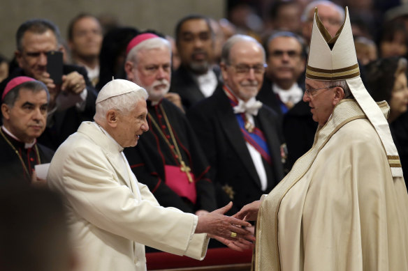 Pope Emeritus Benedict XVI, left, greets Pope Francis in St Peter’s Basilica at the Vatican, in 2015.