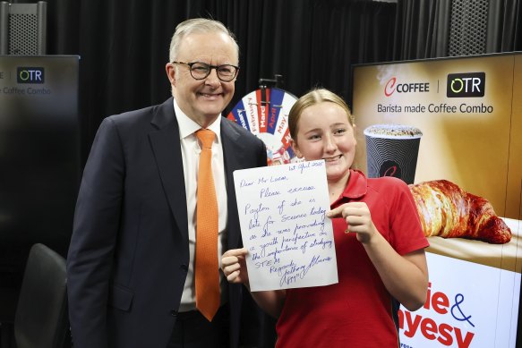 Payton Oddy, daughter of host Jodie Oddy, poses with the PM and a note he wrote for her teacher, after she came to the studio to meet him.