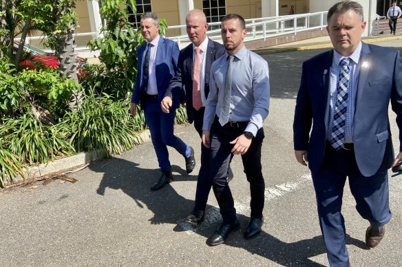 Zachary Rolfe (without jacket) leaving court flanked by NT Police Association president Paul McCue (right) and Police Federation of Australia president Ian Leavers (second from left).