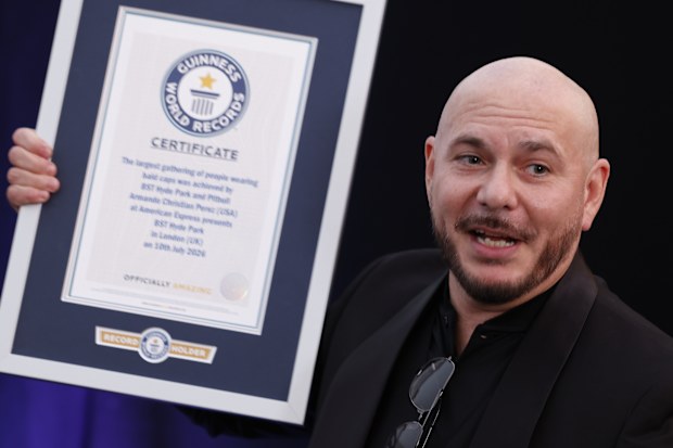 Pitbull, is presented with a Guinness World Record certificate for the largest gathering of people wearing bald cap ahead of his performance at at BST Hyde Park in London