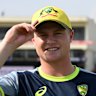 Ollie Peake tries on his new Australian cap before play.
