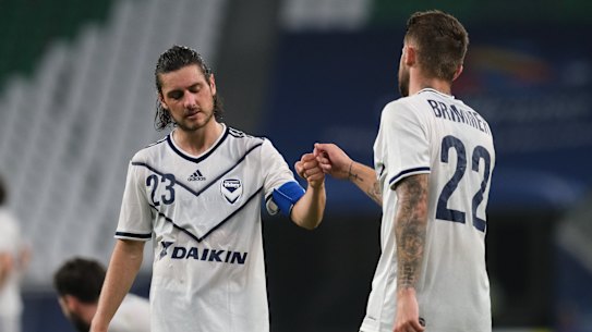 Jake Brimmer and Marco Rojas console each other after Melbourne Victory’s loss in Qatar. 