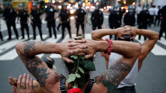 Protesters kneel in front of New York City Police Department officers.