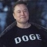 Elon Musk flashes his t-shirt that reads “DOGE” to the media as he walks on South Lawn of the White House, in Washington on Sunday (Monday AEDT).