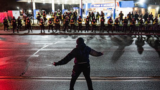 A demonstrator faces off with police during a protest against the fatal shooting of Daunte Wright.