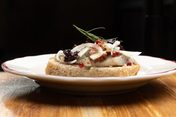 Sledz, marinated herring on spelt bread with onion, fennel, pink peppercorns and red currants.