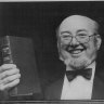 Thomas Keneally displays his cheque and book, after he was awarded the 1982 Booker Prize.