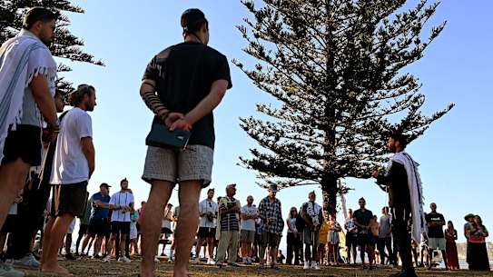 Rabbi Yossi Friedman (right) leads people in prayers at Archer Park last week.