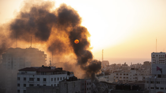 Smoke is seen from a collapsed building after it was hit by Israeli airstrikes on Gaza City.