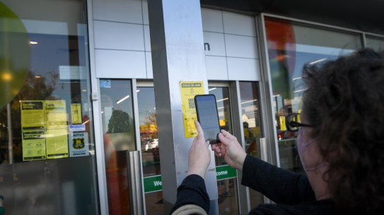 People scanning QR codes at Woolworths in Preston.
