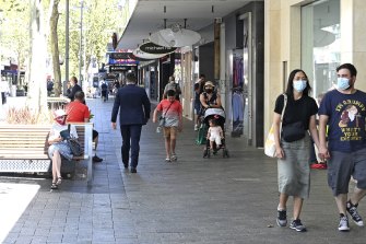Shoppers walk through Hay Street Mall, some in masks and others not, on January 27.