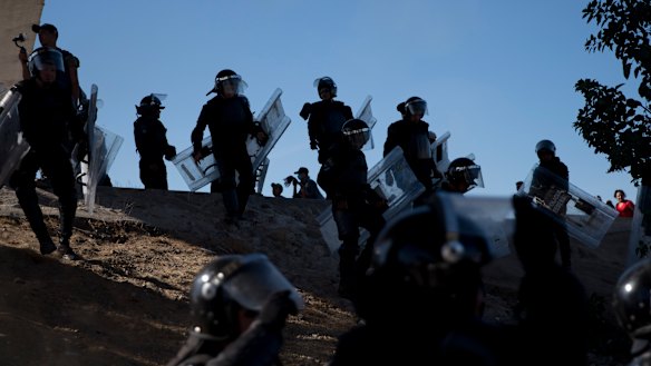 Mexican police spread out as they try to keep migrants from getting past the Chaparral border crossing in Tijuana.
