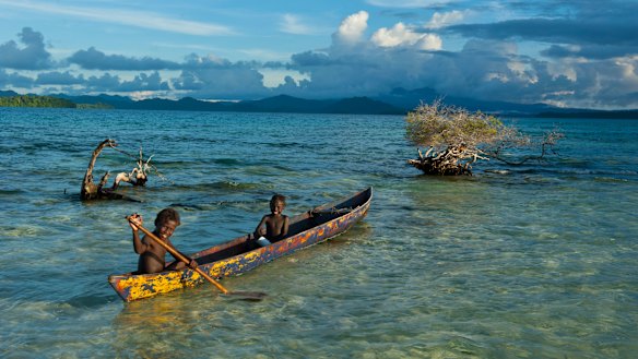 Boys fish in the Marovo Lagoon in the Solomon Islands.