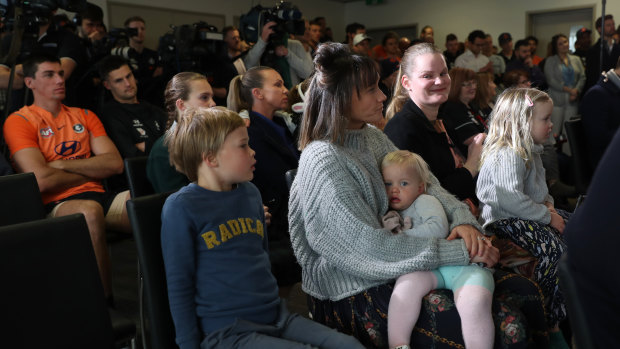 Carlton players and Teague's family members watch his press conference.