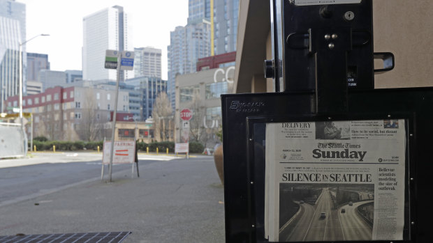 The street next to a Seattle Times newspaper box in front of the building that houses its newsroom is empty as the US economy takes a hit.