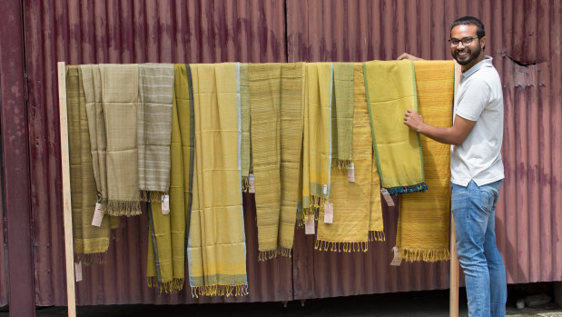 In this image from Keith Recker's True Colors, Nitin Gupta, a member of a non-profit Indian textiles venture called Avani, hangs silks dyed using an invasive weed.  