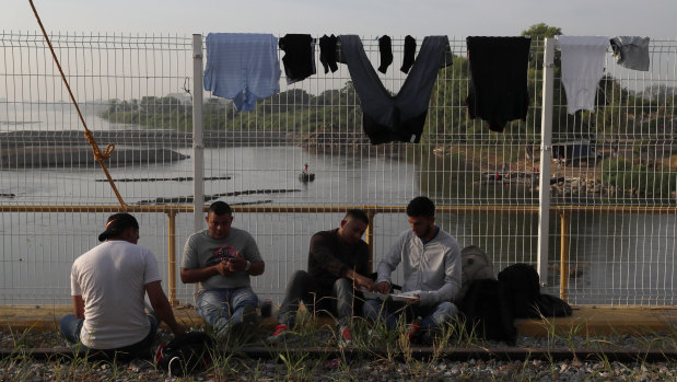 Migrants eat breakfast on the border bridge between Mexico and Guatemala as they wait for their visas to be processed.