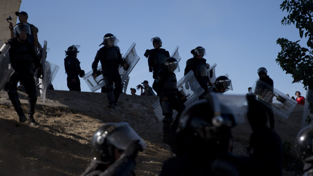 Mexican police spread out as they try to keep migrants from getting past the Chaparral border crossing in Tijuana.