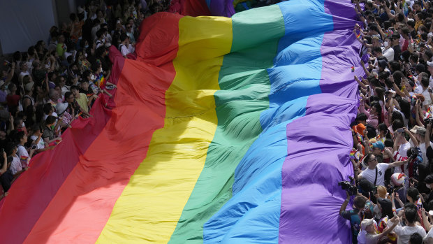 Participants hold a rainbow flag during a Pride Parade in Bangkok in June.