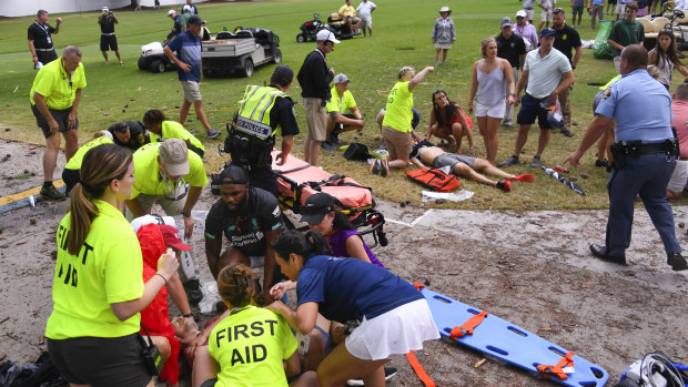 Freak event: Spectators receive treatment after a lightning strike on the East Lake Golf Club course left several injured in Atlanta.