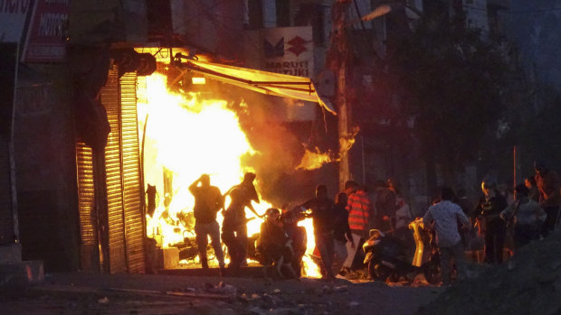 A shop is set on fire during violence between two groups in New Delhi, India.