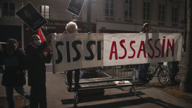 People hold a banner that reads, 'Sissi killer,' as they stage a protest against the Egyptian President Abdel-Fattah el-Sisi by the National Assembly in Paris. 