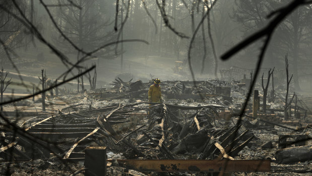 A firefighter searches for human remains in a trailer park destroyed in the Camp Fire in Paradise, California.