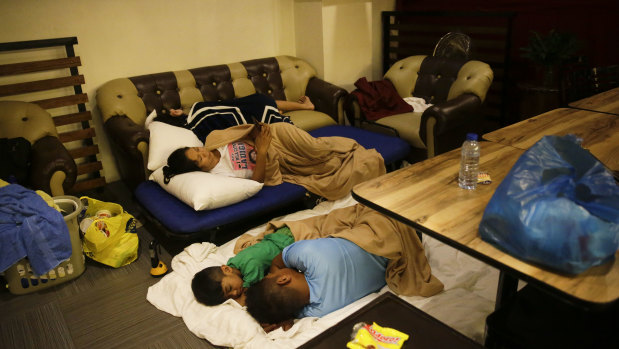 Guests sleep inside a hotel restaurant after the roof of their room was partly damaged due to strong winds from Typhoon Mangkut in Tuguegarao.