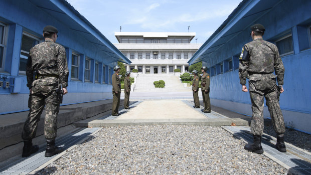 South Korean soldiers (foreground) and North Korean soldiers (background) stand guard in the Demilitarised Zone.