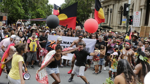 Indigenous protesters dance during the march through the CBD.
