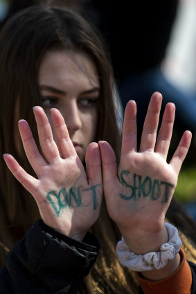A demonstrator holds out her hands displaying the words "Don't shoot" during a school walkout protesting against the National Rifle Association in Washington, DC.