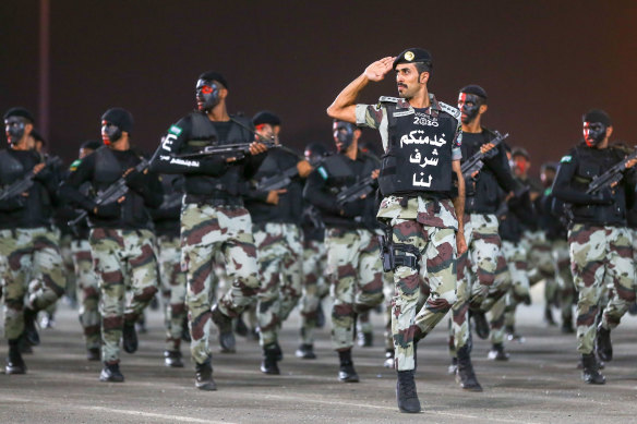 Saudi security forces parade on the eve of the Haj. The writing on the officer's chest reads "serving you is an honour for us".