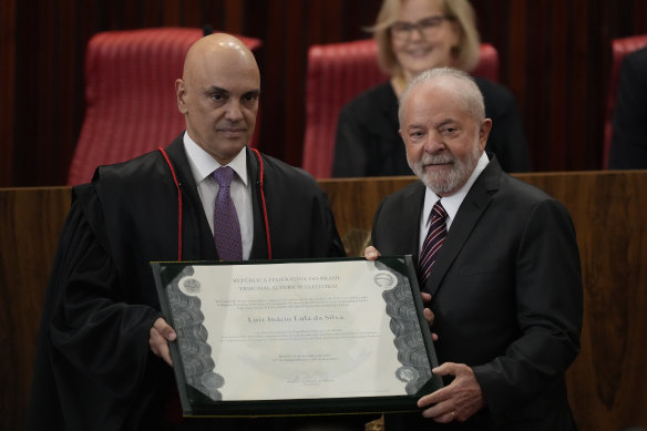 Brazilian President-elect Luiz Inacio Lula da Silva, right, holds his election certificate with Supreme Court Judge Alexandre de Moraes in Brasilia on Monday.
