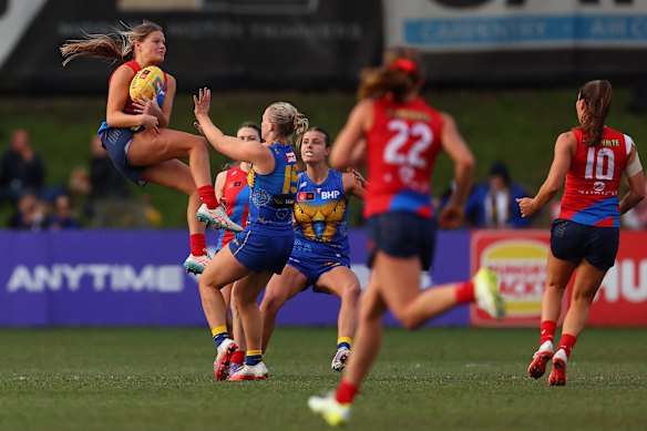 Jordyn Allen of the Demons marks the ball strongly.