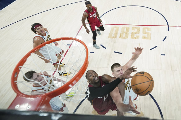 Denver Nuggets centre Nikola Jokic, right, and Miami Heat centre Bam Adebayo, compete for a rebound. 