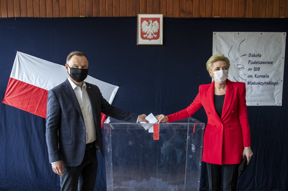 Incumbent Andrzej Duda, left, and his wife Agata Kornhauser Duda cast their votes in Poland's presidential election on Sunday.